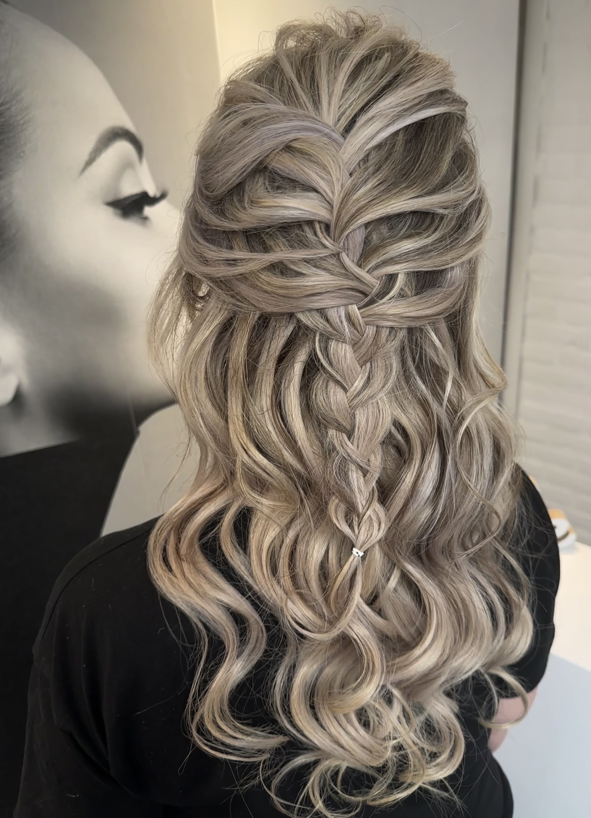 Lang blond haar met golven en een half opgestoken vlecht, gemaakt bij JND Hair&Beauty